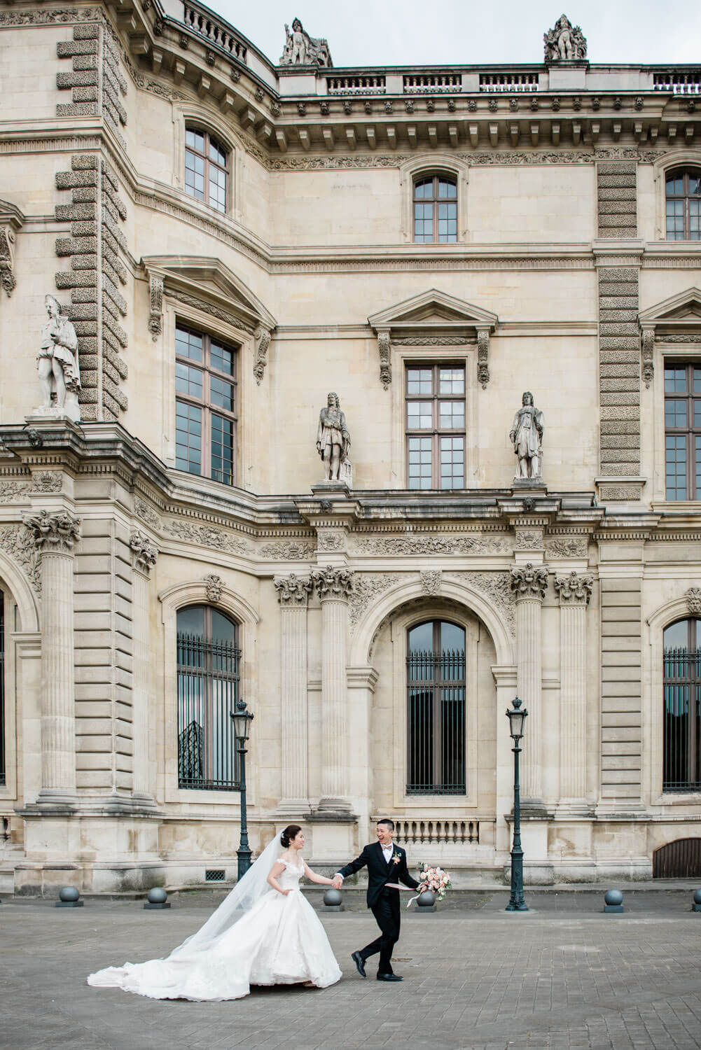 Een lopend bruidspaar tijdens hun bruiloft in Parijs, gefotografeerd door een trouwfotograaf in Parijs